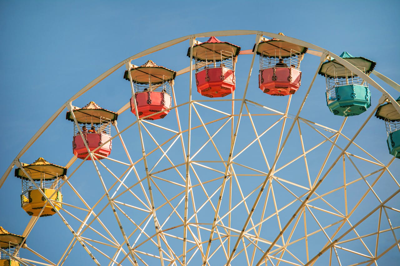 A vibrant Ferris wheel with colorful gondolas set against a clear blue sky, evoking a sense of joy and adventure.